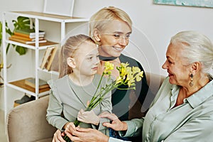 Little Girl Giving Flowers to Grandma on Birthday