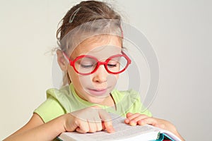 Little girl in glass put finger on text