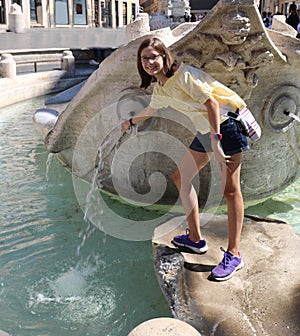 Little girl with glasses on the fountain called BARCACCIA in Rom photo