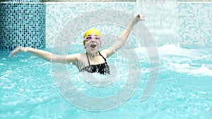 little girl with glasses having fun in the pool of the water park