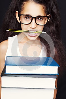 Little girl with glasses and pencil holds books