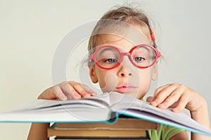 Little girl in glasses read book