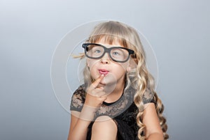 Little girl in glasses thinking