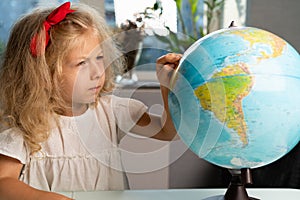 little girl with a globe, study geography, back to school