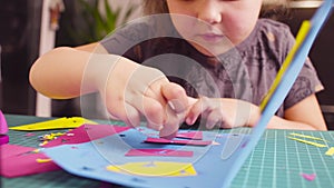 Little girl glueing colored paper