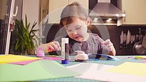 Little girl glueing colored paper