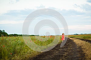 Little girl goes in dirty dirt road after rain.