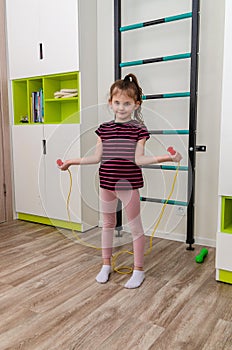 A little girl goes in for sports in her room.