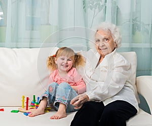 Little girl with grandmother on a sofa