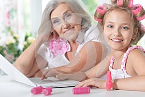 Little girl with granny using laptop