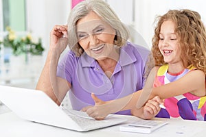 Little girl with granny using laptop