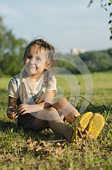 Little girl on the grass in summertime