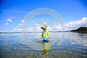 Little girl in green shirt playing in the water. Whangarei beach