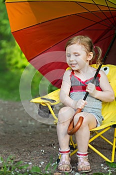 Little girl with a grimy legs sitting on a chair