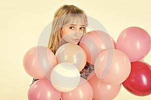Little girl with hairstyle hold balloons. Beauty and fashion, punchy pastels. Kid with balloons at birthday. Small girl