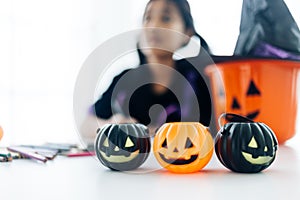 Little girl in halloween costume making jack-o-lantern