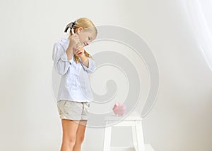 Little girl with hammer by the pink pig piggy bank