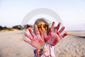 Little girl hands covered with colored powder
