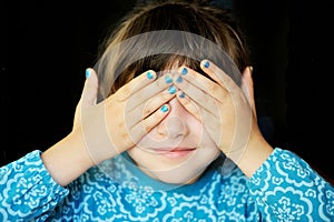 Little girl with hands covering her eyes