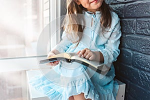 Little girl hands folded in prayer on a Holy Bible in church for faith concept in vintage color tone