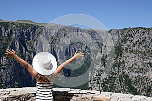 Little girl with hands up on the viewpoint Vikos gorge