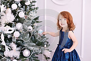 Little girl. Happy child. Blue dress. Christmas decorations