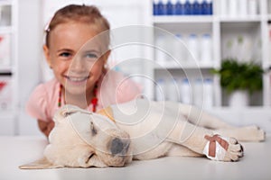 Little girl happy that her puppy got away with only a bandage on its paw