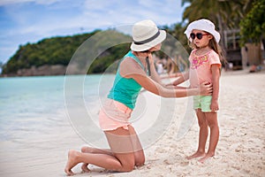 Little girl and happy mom during summer beach