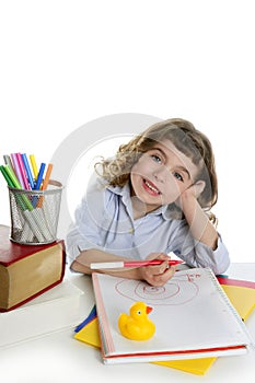 Little girl happy student on desk writing