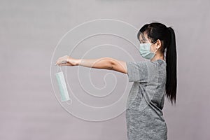 Little girl has sterile medical  mask protect herself from Coronavirus COVID-19 isolated on gray background
