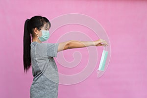 Little girl has sterile medical  mask protect herself from Coronavirus COVID-19 isolated on pink background
