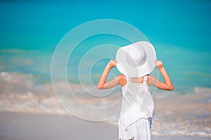 Little girl in hat at the beach during caribbean vacation