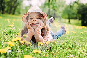 Little girl with hat lying on the grass