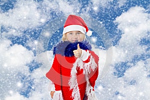 Little girl in hat of Santa Claus on background of sky