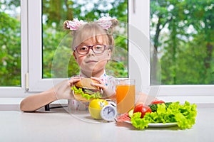 Little girl is having dinner sitting by the window, healthy eating.