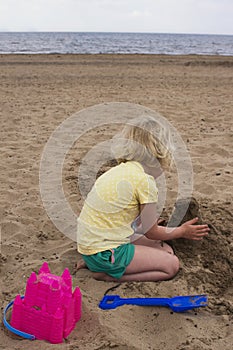 A little girl having fun building sand castles on a Scottish beach