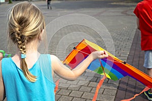 Little girl having fun flying a kite in summer