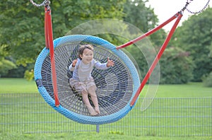 Little girl having fun in one rounded swing