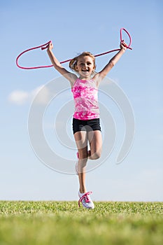 Little girl having fun outdoors with a skipping