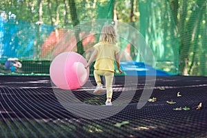 Little girl having fun at a rope playground. The girl is playing on net ropes.