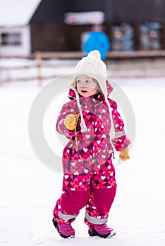 Little girl having fun at snowy winter day