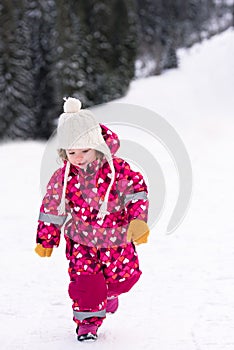 Little girl having fun at snowy winter day