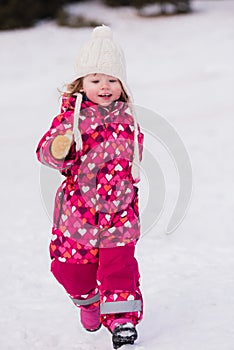 Little girl having fun at snowy winter day