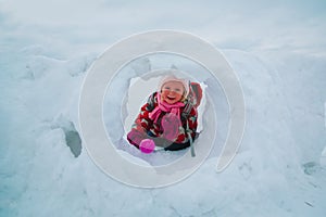 Little girl having fun in winter snow cave, kids winter fun