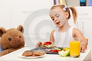 Little girl having a healthy snack sitting at the table with her