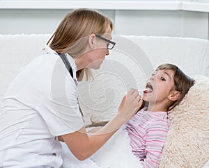 Little girl having his throat examined by health professional