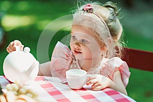 Little girl having a tea party in the backyard