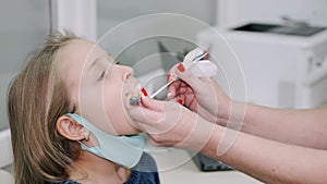 Little girl having a throat examination at pedeatrician`s office