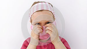 Little girl in headband and protective pink mask against coronavirus COVID-19 pandemic white background on quarantine