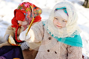 Little girl in a headscarf in the Russian style, with a wooden s